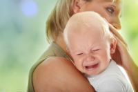 child falls crying in moms arms