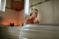 Pregnant woman relaxing tub candle bathroom
