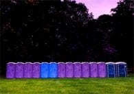 Repeated porto-potties, dusk, purple sky, green grass