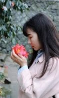 Woman smelling flower tree