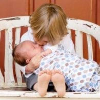 young boy holding his newborn baby brother