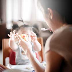 mother feeding baby safe finger foods