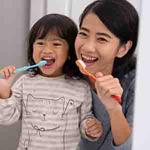 mother and daughter brushing teeth